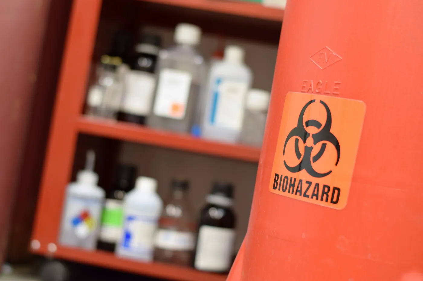 Laboratory storage shelving holding assorted chemical bottles